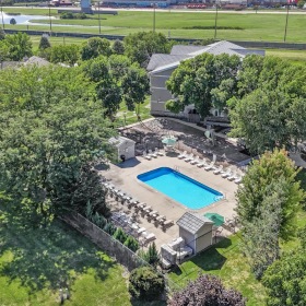a large building with a pool in the middle of a park